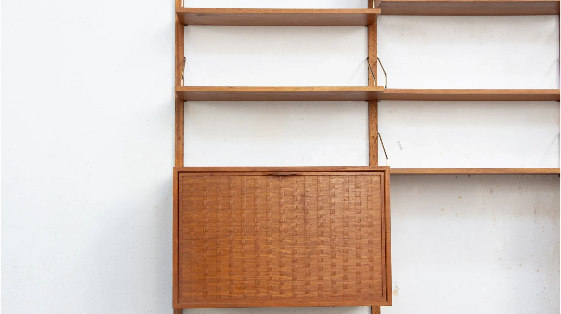 Bibliothèque du designer Danois Poul Cadovius en teck, modèle royal system avec les tiges en laiton, vue sur le module porte tressé en placage