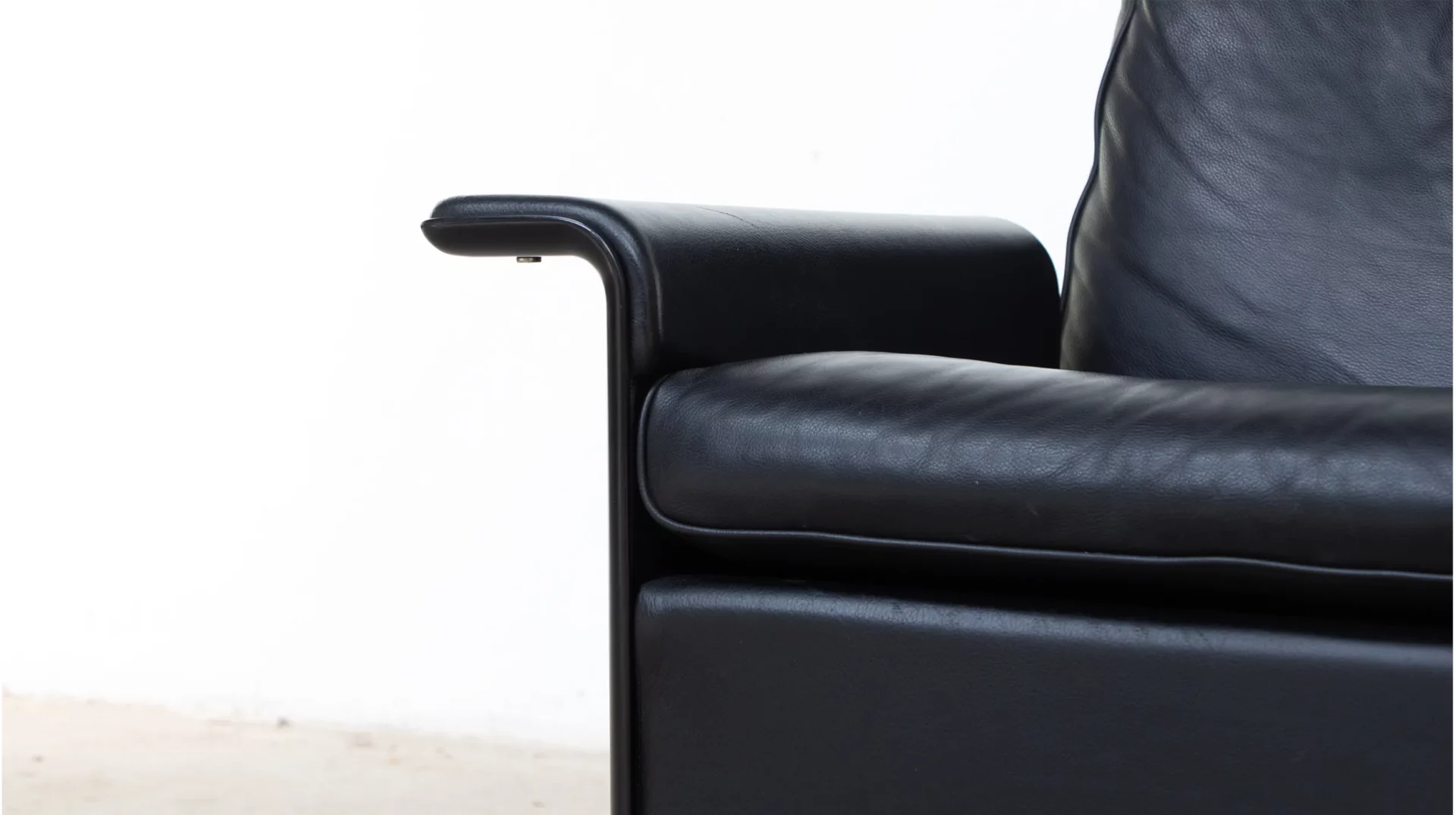Détail assise et accoudoir cuir noir du lounge chair Dieter Rams RZ62 pour vitale