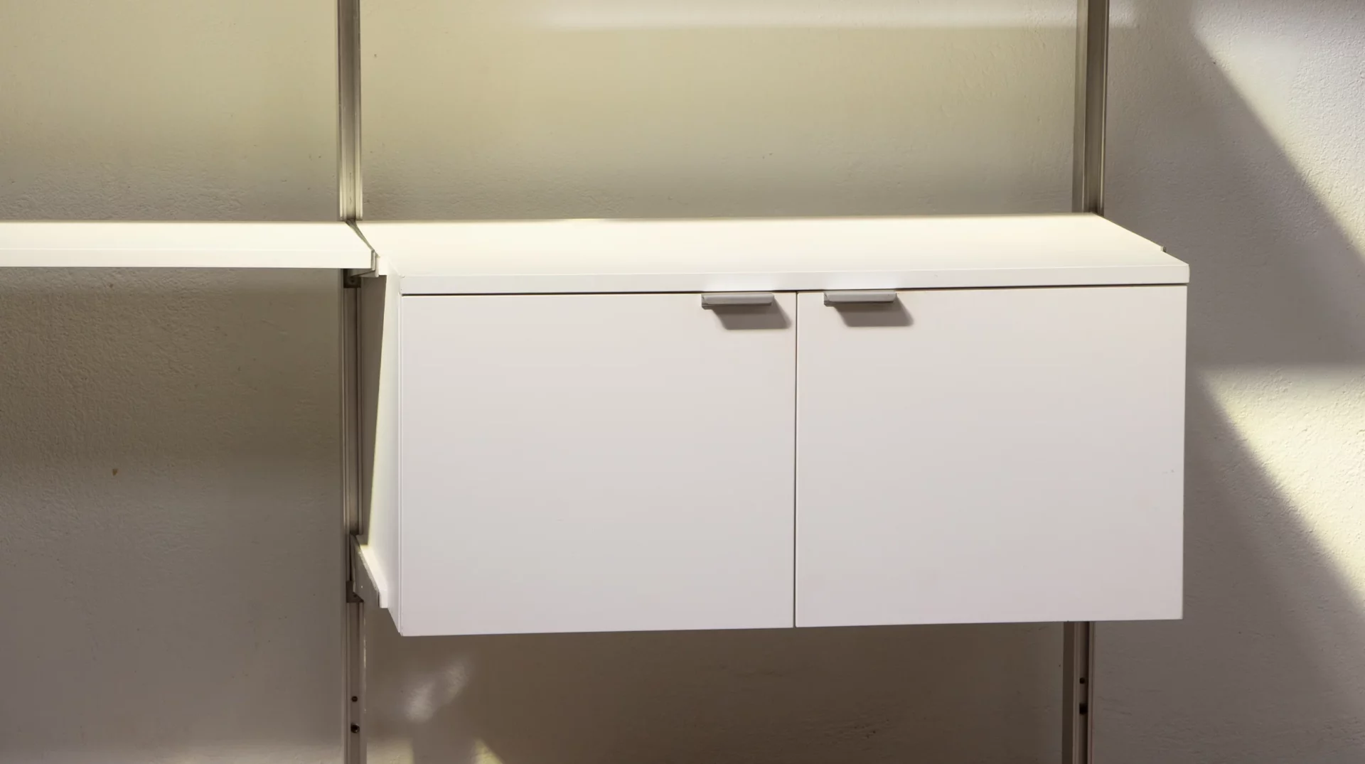 Bibliothèque CSS George Nelson pour Herman Miller, Mobilier International, laquée blanche, aluminium, vue d'un élémént : le module avec les portes battantes
