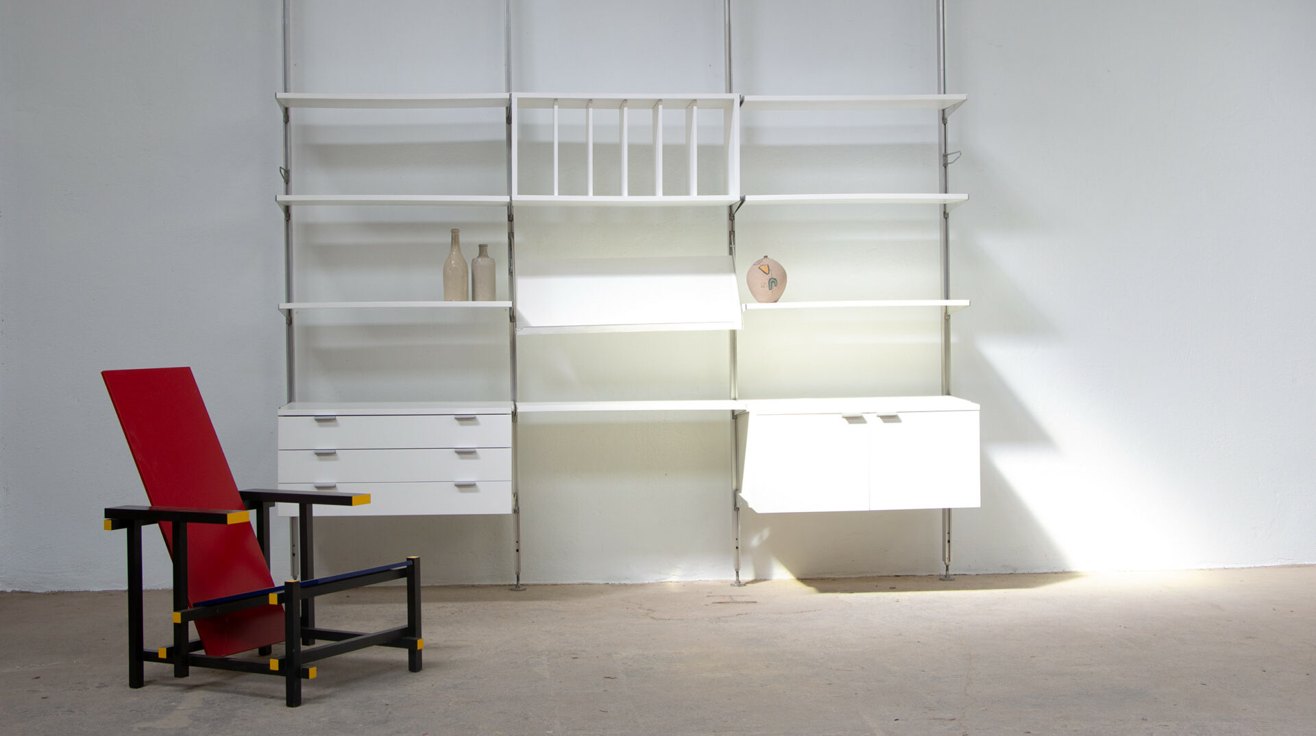 Bibliothèque CSS George Nelson pour Herman Miller, Mobilier International, laquée blanche, système sol/plafond, vue d'ensemble avec des céramiques vintage et un fauteuil Gerrit Rietveld