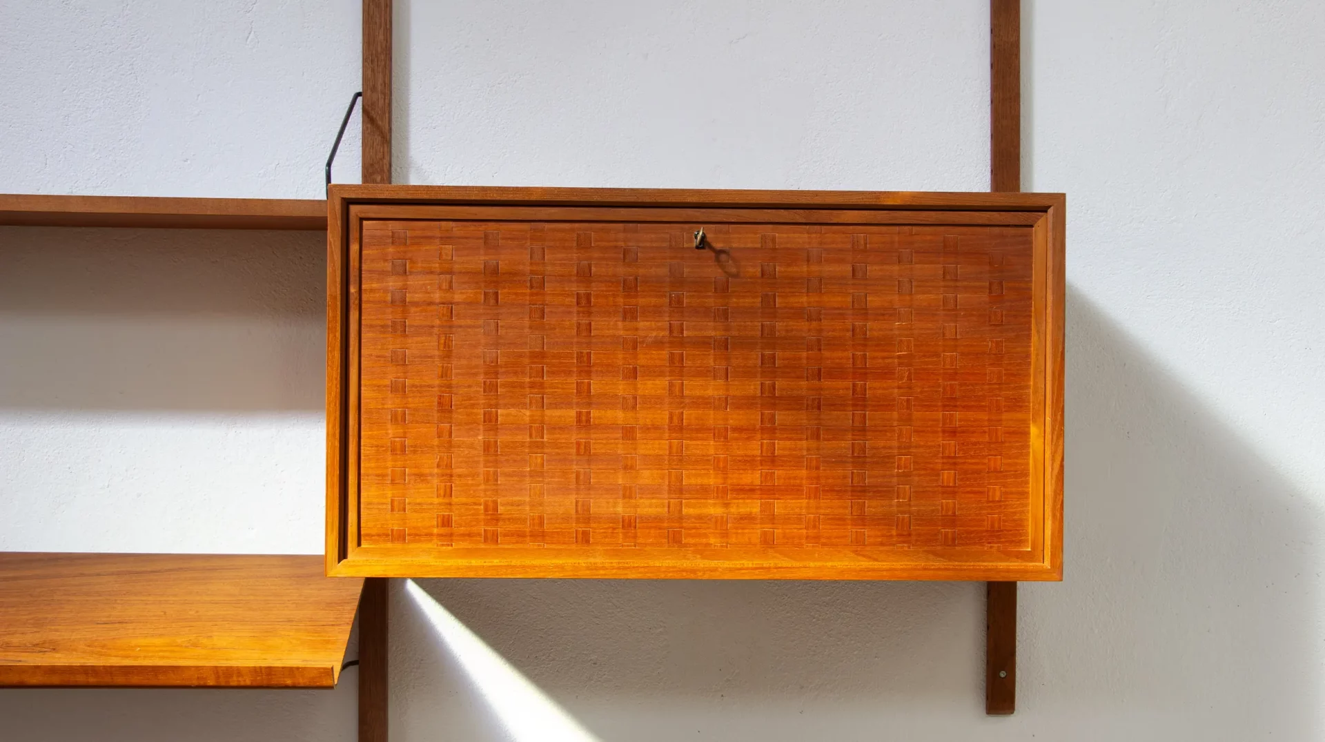 bibliothèque Poul Cadovius en teck, royal system, année 60, gros plan sur la porte en marqueterie.