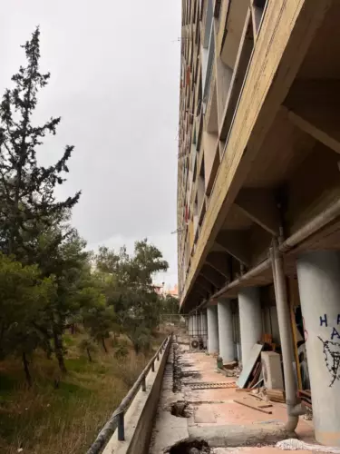 Coursives sous les piliers du bâtiment béton brutaliste de Papaioannou et Finesà Athènes